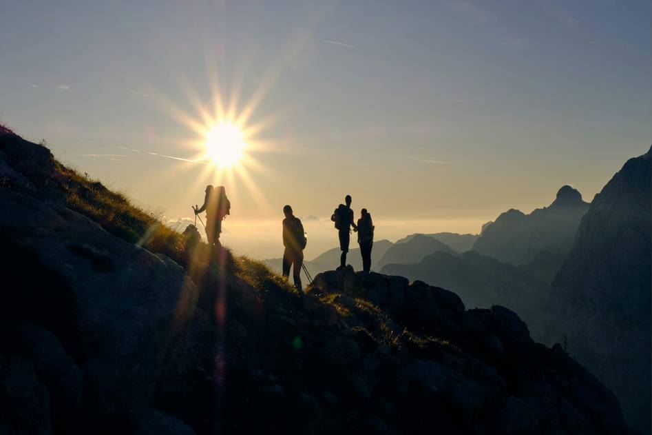 Hiker on scenic mountain trail at sunrise with backpack